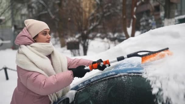 Mujer quitando nieve del coche — Vídeos de Stock