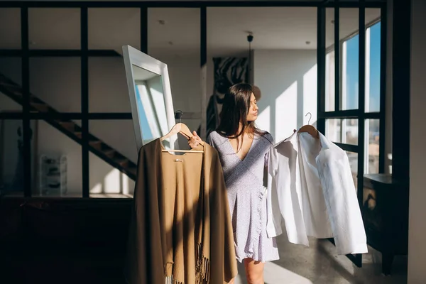 Krásná dívka se snaží šaty v pokoji — Stock fotografie