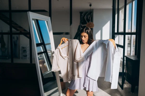 Vacker flicka försöker klänning i rummet — Stockfoto