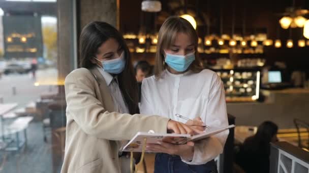 Twee zakenvrouwen met gezichtsmaskers die van mening verschillen over werk — Stockvideo