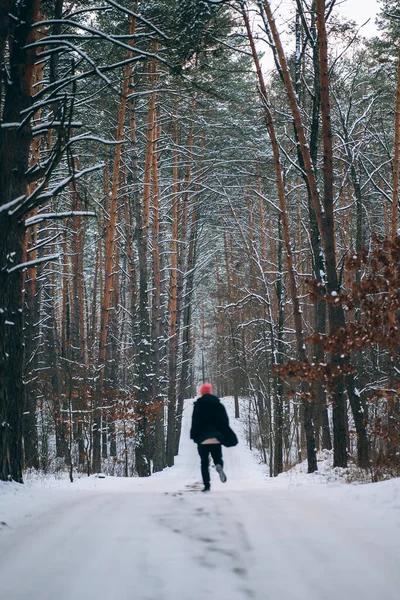 Man op de weg in het midden van het bos, omgeven door sneeuw — Stockfoto