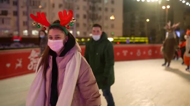 Folk njuter av skridskoåkning på gatan runt julgran i rinken. — Stockvideo