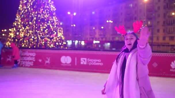 Les gens aiment patiner sur glace dans la rue autour de l'arbre de Noël dans la patinoire. — Video