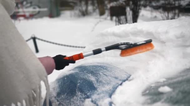 Kobieta usuwająca śnieg z samochodu — Wideo stockowe
