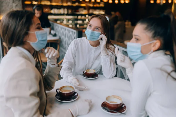 As amigas conheceram-se num café. Use máscaras de proteção médica. — Fotografia de Stock