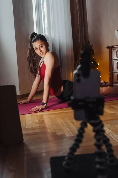 Mujer joven practicando yoga, está comprometida con el profesor en línea. — Foto de Stock