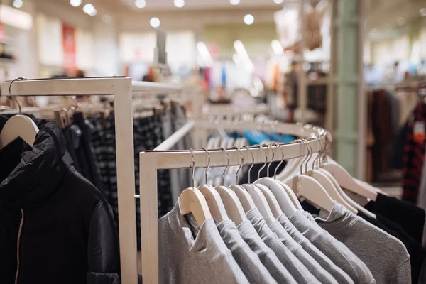 Stilvolle Kleidung auf einem Kleiderbügel in einem Geschäft. Neue Kollektion von Mänteln. — Stockfoto