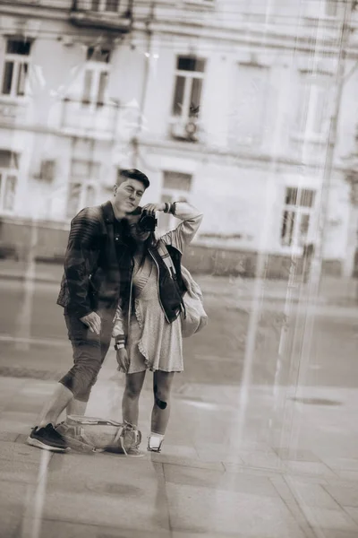 Young couple taking selfie in reflection of glass building — Stock Photo, Image