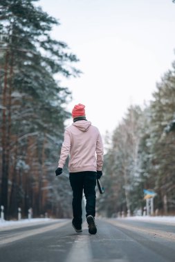 Ormanın ortasında, karla çevrili bir yolda duran bir adam.