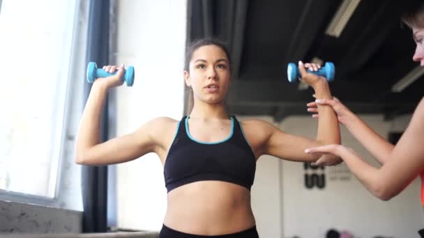 Jovem mulher personal trainer ajudando com o treino no ginásio — Vídeo de Stock