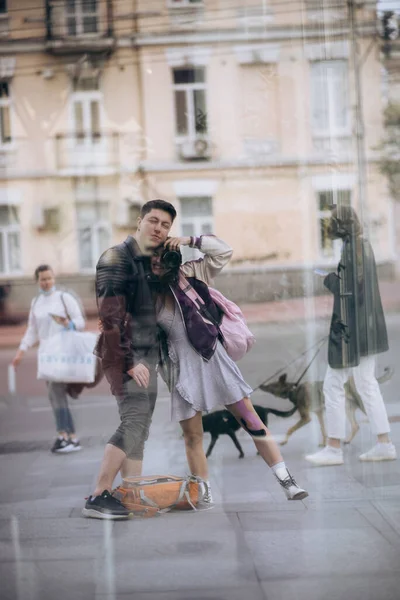 Young couple taking selfie in reflection of glass building — Stock Photo, Image