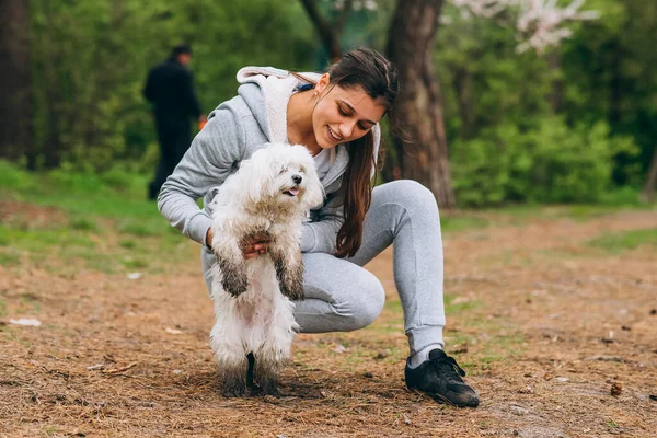 Vacker kvinna som håller en hund i sina armar — Stockfoto