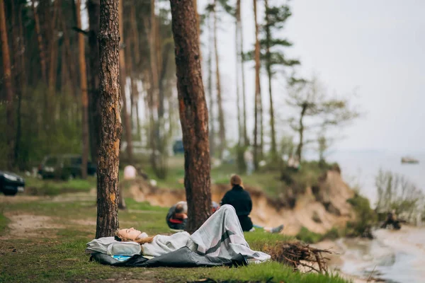 Uma jovem encontra-se na margem de um pequeno lago junto à floresta. — Fotografia de Stock