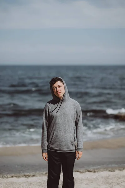 Snygg man poserar på en bakgrund av havet — Stockfoto