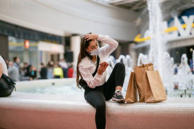 İçerde akıllı telefon kullanan bir kadın. Alışveriş merkezinde mesajlaşma ve iletişim