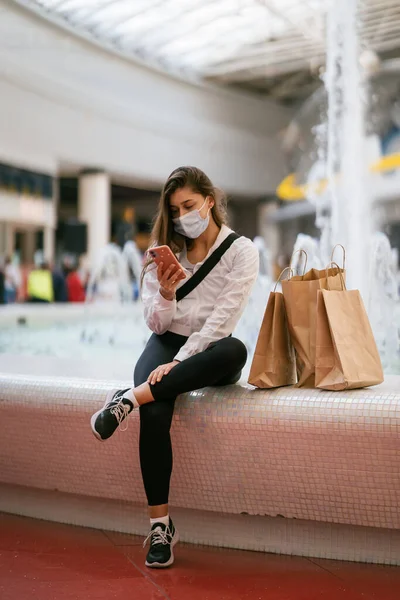 Женщина использует смартфон в помещении. Переписка и общение в торговом центре — стоковое фото