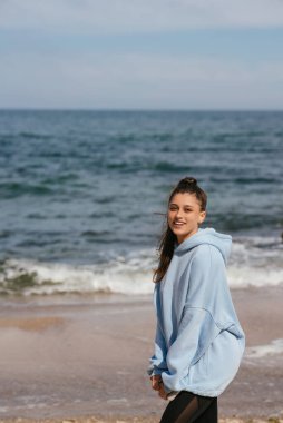 Halka açık bir plajda güzel bir kadın yürüyüşünden sonra sportif bir bakışla