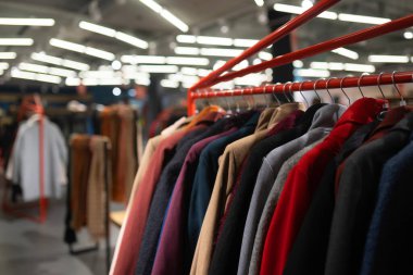 Mağazadaki askıda şık kıyafetler. Yeni palto koleksiyonu.