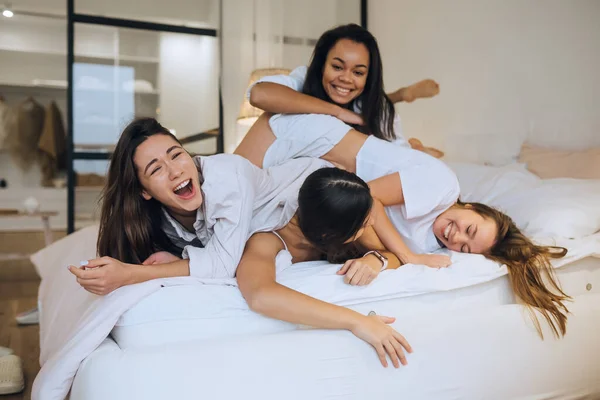 Chicas jóvenes positivas mujeres amigos en el interior de la cama en la despedida de soltera en casa. — Foto de Stock