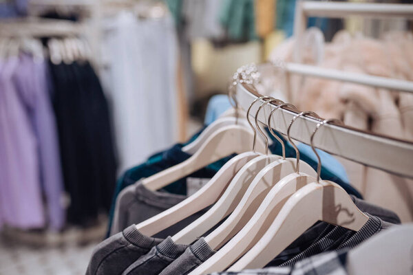 Stylish clothes on a hanger in a store. New collection of coats.