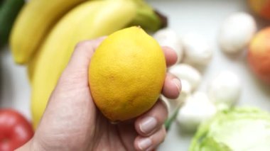 Bir erkeğin eli bir limonu tutar, doğru beslenme konsepti.