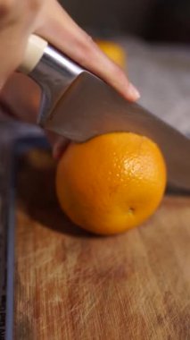 Bayanlar taze turuncu mutfak üzerinde kesme eller