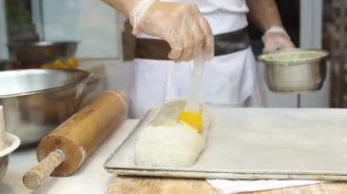 Bir adam satılık elmalı turta hazırlar. Fırçayla kaplanarak