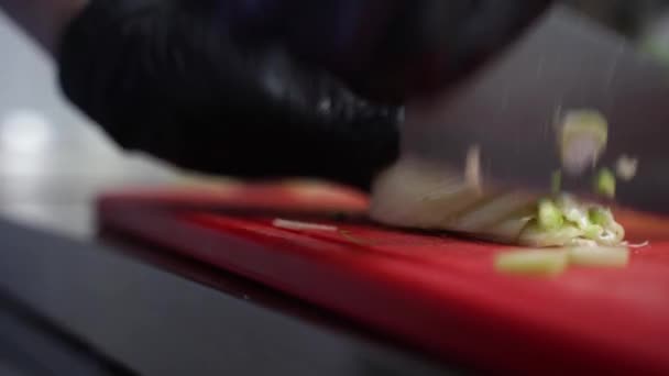 Szef kuchni kroi cebulę na desce. — Wideo stockowe