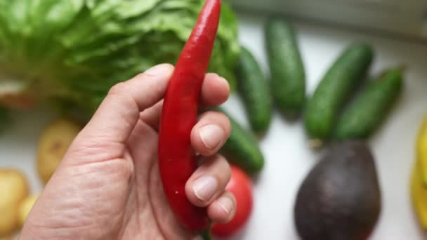 Mano masculina sosteniendo chile, concepto de nutrición adecuada. — Vídeos de Stock