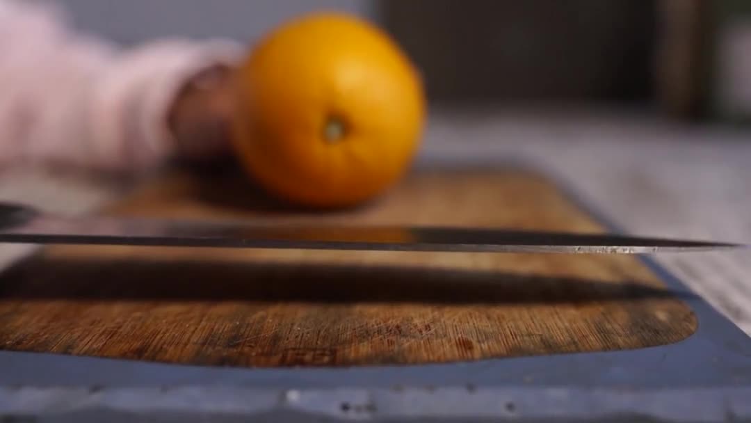 Womans hands cutting fresh orange on kitchen — Stock Video