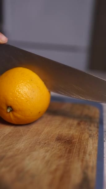 Womans hands cutting fresh orange on kitchen — Stock Video