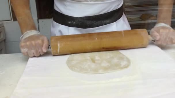 Un hombre prepara un strudel de manzana para la venta. Prepara la masa — Vídeo de stock