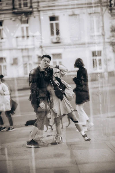 Casal jovem que toma selfie na reflexão do edifício de vidro — Fotografia de Stock