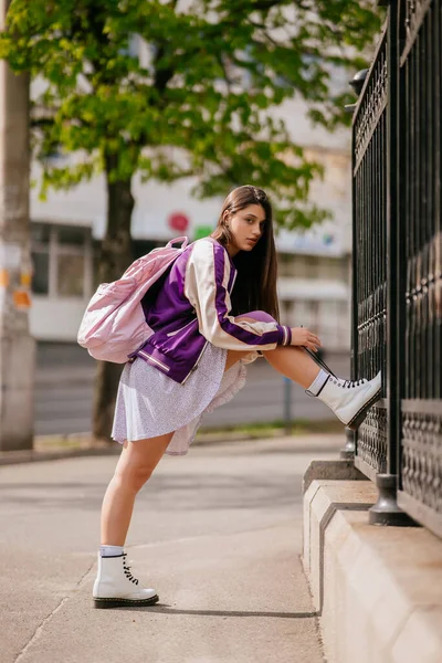 Giovane donna legando i lacci delle scarpe sui suoi stivali bianchi — Foto Stock