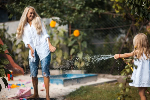 Fille et mère jouant avec l'eau — Photo