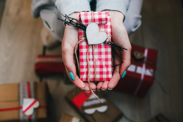 A gift in hands, many gifts on a ground . — Stock Photo, Image