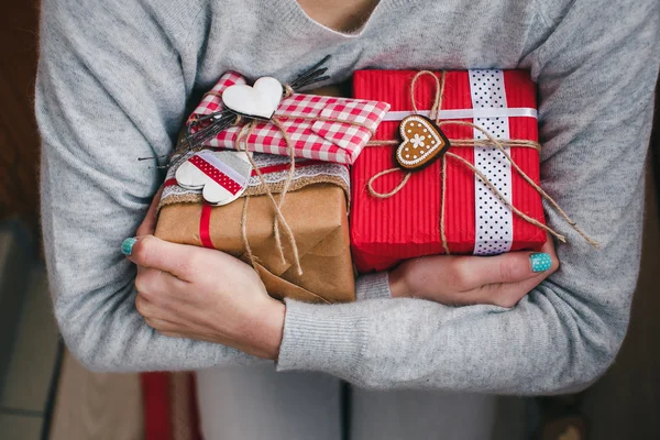 A gift in hands, many gifts on a ground . — Stock Photo, Image