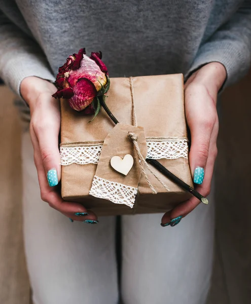 Een gift in handen, vele geschenken op een grond . — Stockfoto