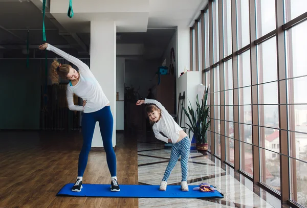 Twee meisjes van verschillende leeftijden maken van yoga — Stockfoto