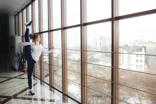 Madre haciendo super alta pierna estiramiento en el gimnasio —  Fotos de Stock