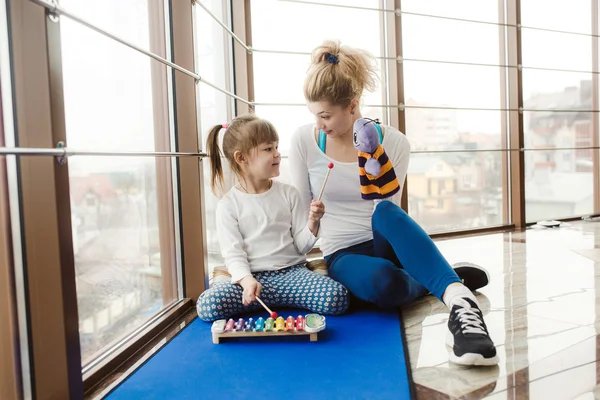 Moeder en dochter spelen met speelgoed in de sportschool — Stockfoto