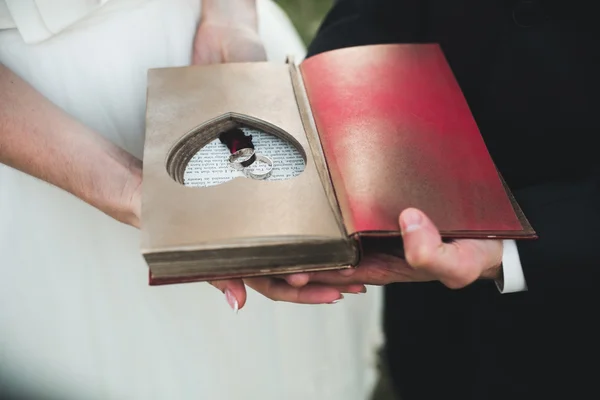 Encantador libro vintage con corazón hecho a mano en el que se encuentra el anillo . —  Fotos de Stock