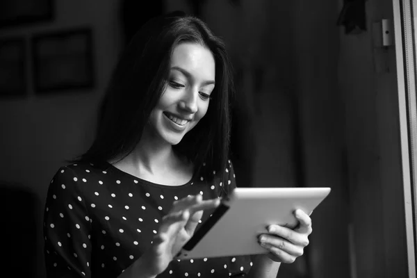 Schönes Mädchen, das an einem Tablet arbeitet und lächelt — Stockfoto