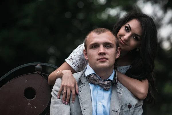 Молодая европейская пара обнимается на скамейке в парке — стоковое фото