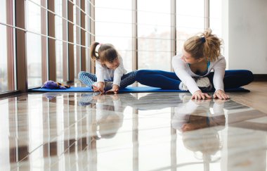 Anne ve kızı spor salonunda yoga yapmak