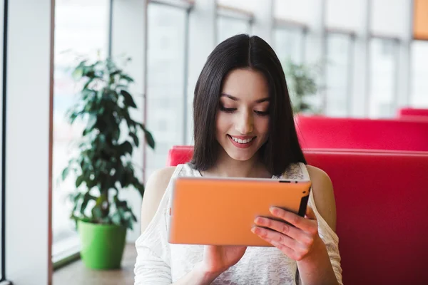Vacker flicka arbetar på en Tablet PC och ler — Stockfoto