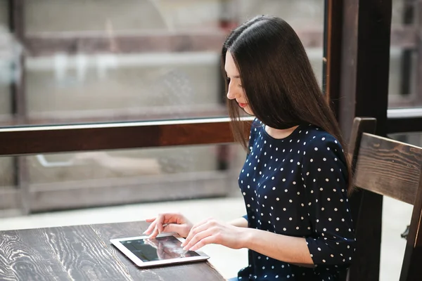 Krásná dívka pracuje na tabletu a usmívá se — Stock fotografie