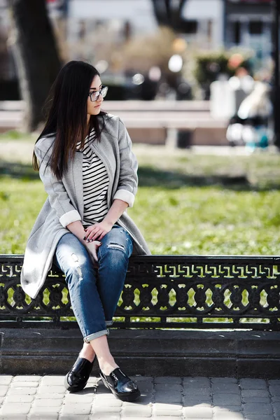 Prachtige model in glazen zitten op het hek — Stockfoto