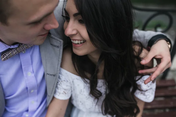 Joven pareja europea abrazándose en un banco del parque —  Fotos de Stock