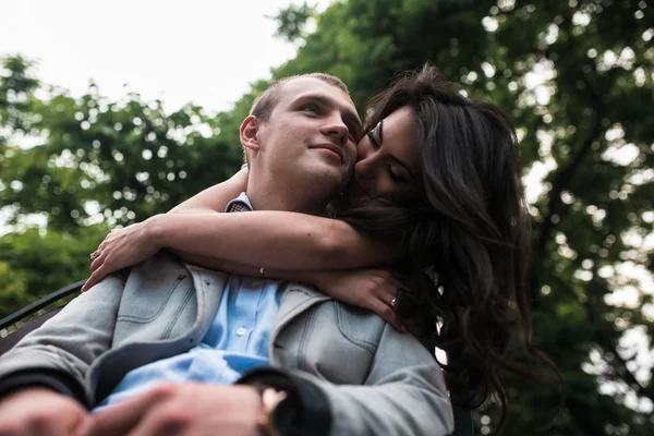 Fiatal európai pár cuddling egy padon — Stock Fotó